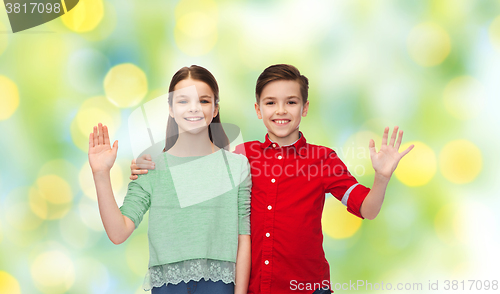 Image of happy boy and girl waving hand