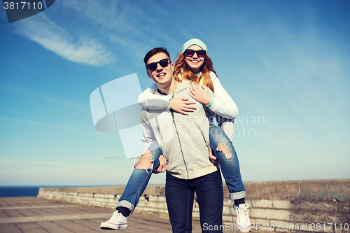 Image of happy teenage couple in shades having fun outdoors