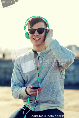 Image of happy young man in headphones with smartphone