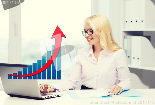 Image of smiling businesswoman with laptop and papers