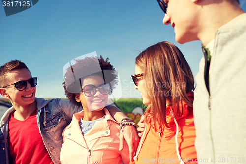 Image of happy teenage friends in shades talking on street