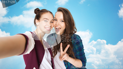 Image of happy friends taking selfie and showing peace