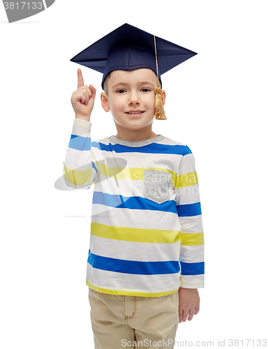 Image of happy boy in bachelor hat pointing finger up