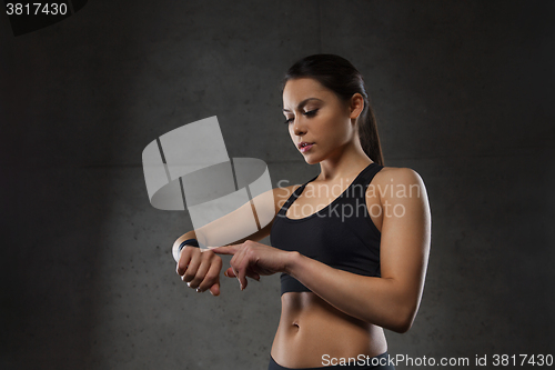 Image of young woman with heart-rate watch in gym