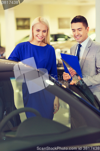 Image of happy woman with car dealer in auto show or salon