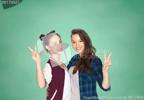 Image of happy teenage student girls showing peace sign