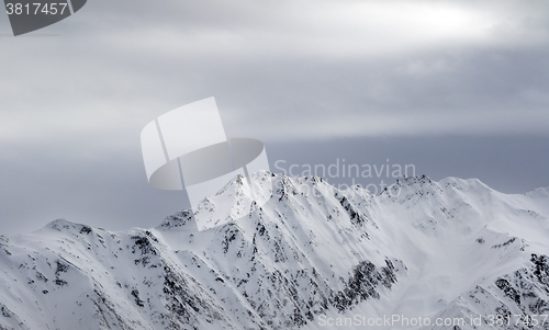 Image of High snowy mountains and gray sky before blizzard