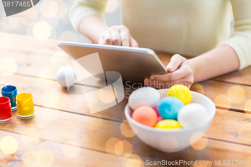 Image of close up of woman with tablet pc and easter eggs