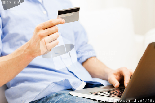 Image of close up of man with laptop and credit card