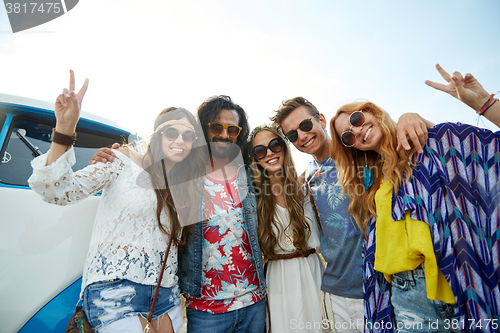 Image of hippie friends over minivan car showing peace sign