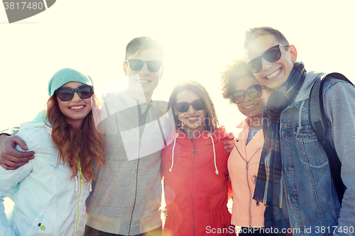 Image of happy teenage friends in shades hugging on street