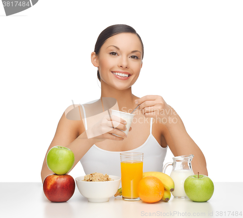 Image of young woman eating healthy breakfast