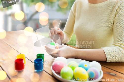 Image of close up of woman hands coloring easter eggs