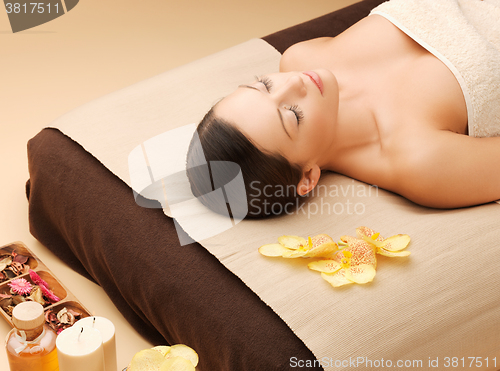 Image of woman in spa salon lying on the massage desk