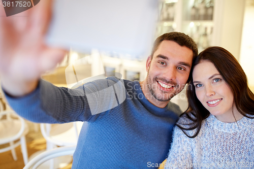 Image of couple taking smartphone selfie at cafe restaurant