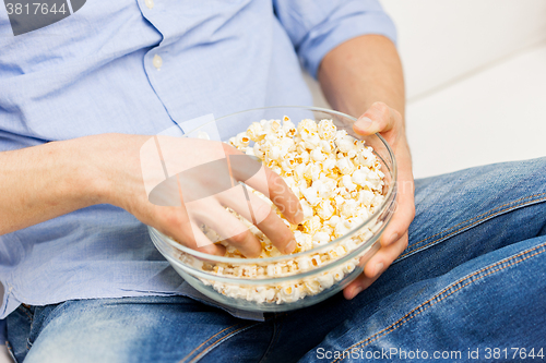 Image of close up of man eating popcorn at home