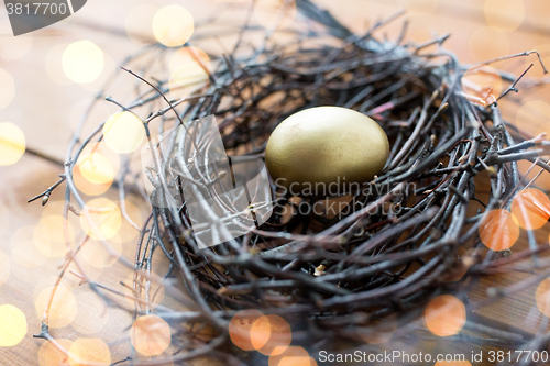 Image of close up of golden easter egg in nest on wood