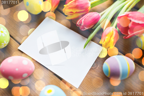 Image of close up of easter eggs, flowers and white paper