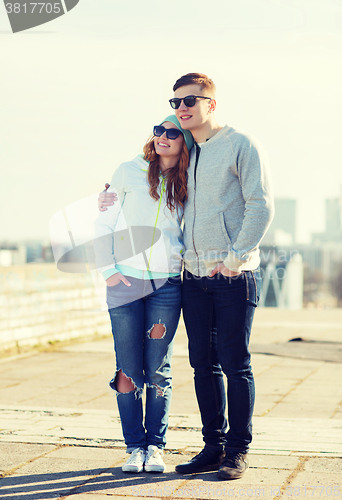 Image of happy teenage couple walking in city