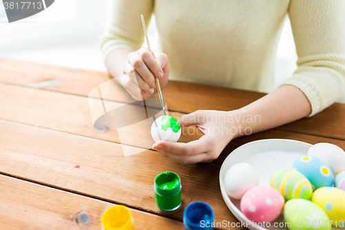 Image of close up of woman hands coloring easter eggs