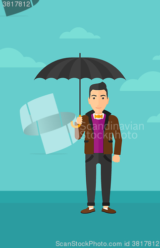 Image of Businessman standing with umbrella.