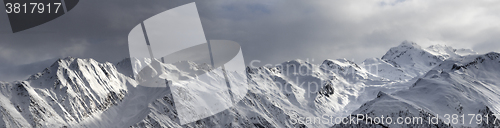 Image of Panoramic view on high sunlight mountains and storm sky before b