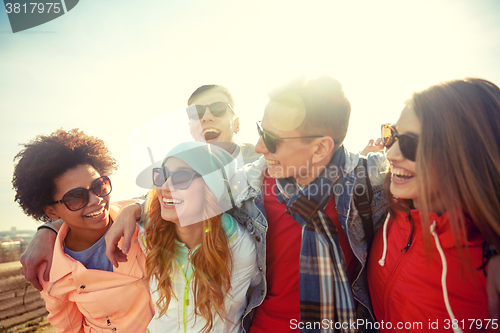 Image of smiling friends in sunglasses laughing on street