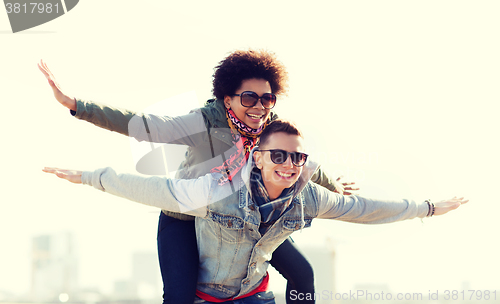 Image of happy teenage couple in shades having fun outdoors