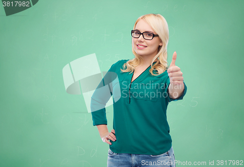 Image of young woman in eyeglasses showing thumbs up