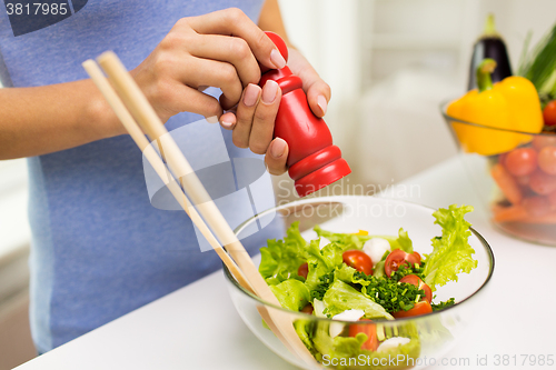 Image of close up of woman cooking vegetable salad at home