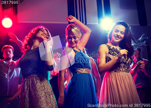 Image of smiling friends dancing in club