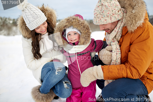 Image of happy family with child in winter clothes outdoors