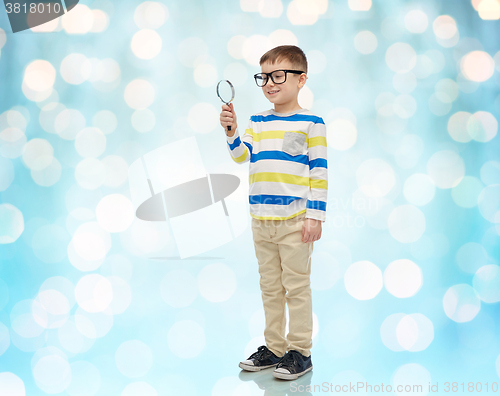 Image of little boy in eyeglasses with magnifying glass