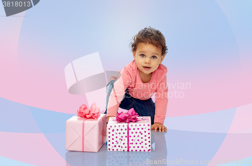 Image of baby girl with birthday presents and confetti