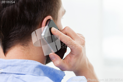 Image of close up of man calling on smartphone at home