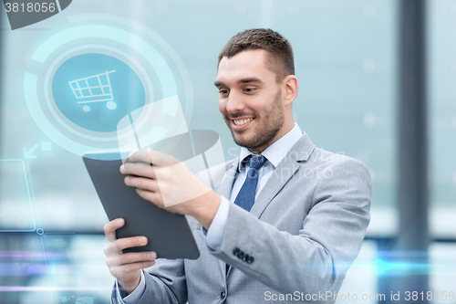 Image of smiling businessman with tablet pc outdoors