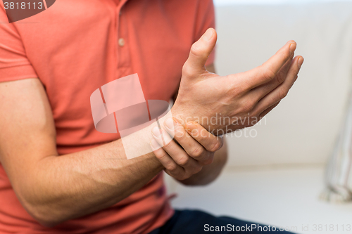 Image of close up of man with  pain in hand at home