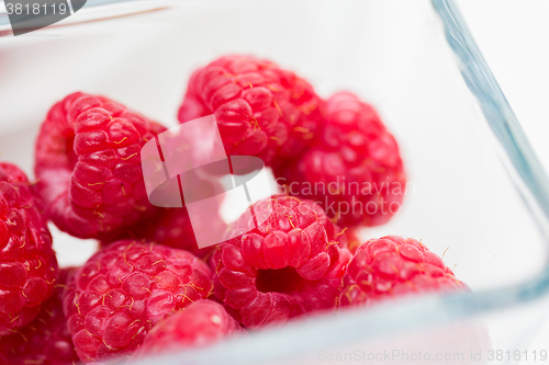 Image of close up of ripe red raspberries in glass