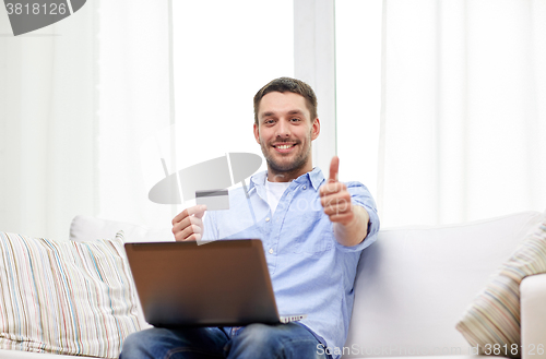 Image of man with laptop and credit card showing thumbs up
