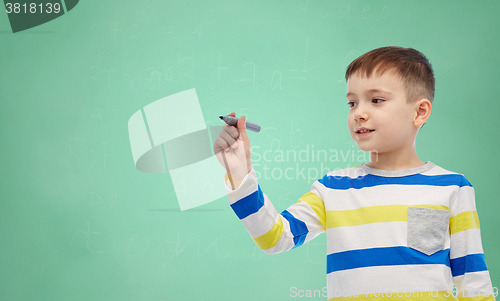 Image of little boy drawing or writing with marker