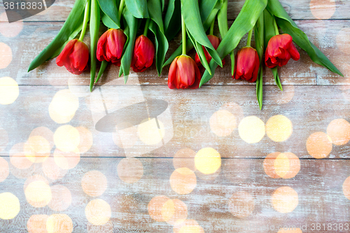 Image of close up of red tulips on wooden background