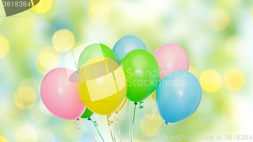 Image of bunch of helium balloons over green lights