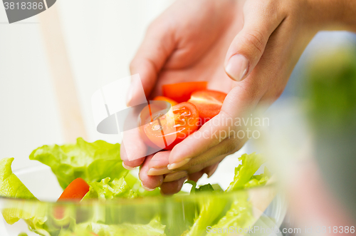 Image of close up of woman cooking vegetable salad at home