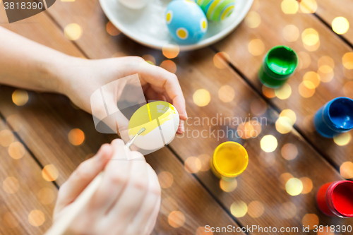 Image of close up of woman hands coloring easter eggs