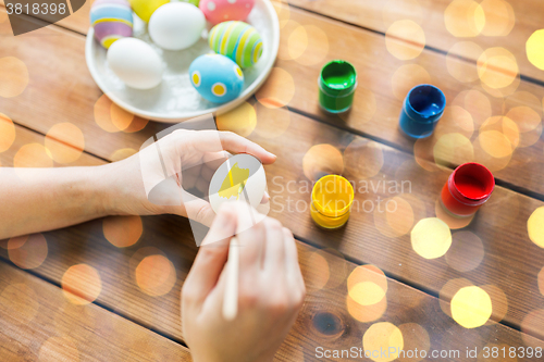 Image of close up of woman hands coloring easter eggs