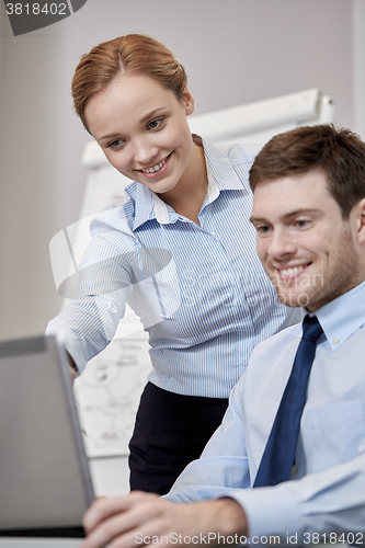Image of smiling businesspeople with laptop in office