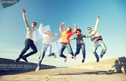 Image of smiling friends in sunglasses laughing on street