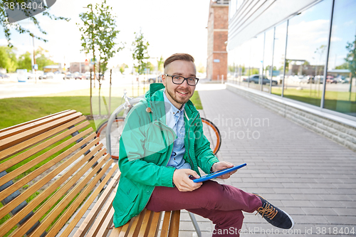 Image of happy young hipster man with tablet pc and bike