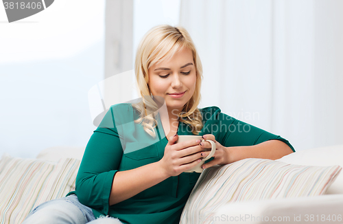 Image of happy woman  with cup of tea or coffee at home