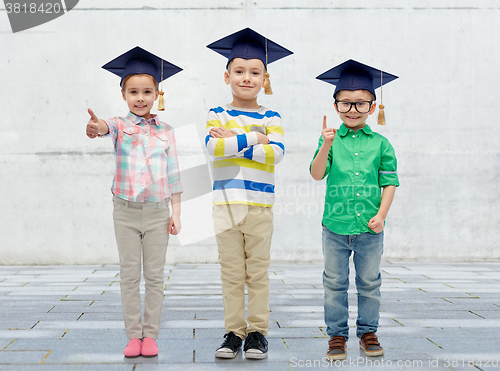 Image of happy children in bachelor hats and eyeglasses